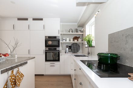 Stilrent kök med kompositbänkskiva och integrerade vitvaror