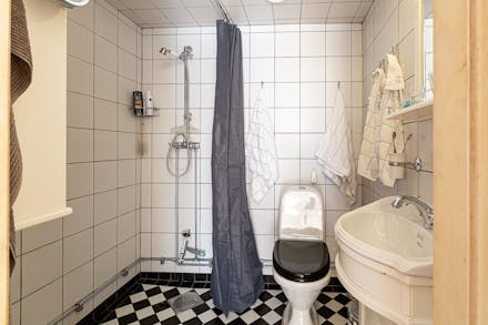 Fräscht badrum med klinkergolv, helkaklade väggar och delvis kaklat tak