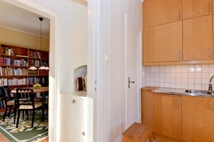 Köket har skafferi samt en serveringsgång med originalskåp som förbinder mot matrum
