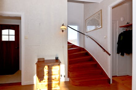 Bred och gåvänlig trappa leder upp till övre plan från inre hall