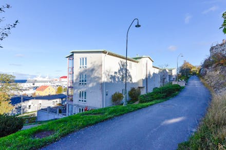 Huskroppen ligger mellan Ravinstigen (entré i markplan) och Palissadgatan (bostaden nås via hiss)