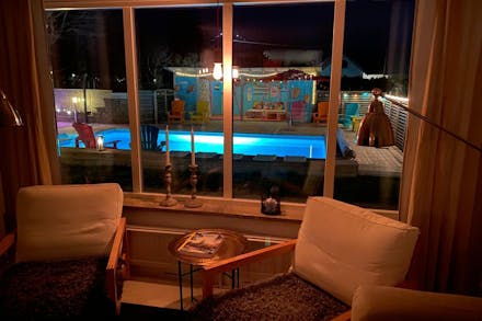 Utsikt från vardagsrummet mot poolen kvällstid