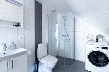 Välutrustat badrum med wc/dusch och kombinerad tvättmaskin/torktumlare