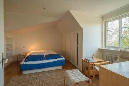 Sovrum 1 med ekparkettgolv och fönster mot Tranhusgatan