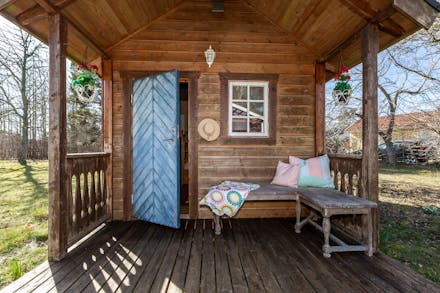 Charmig gäststuga med liten veranda.
