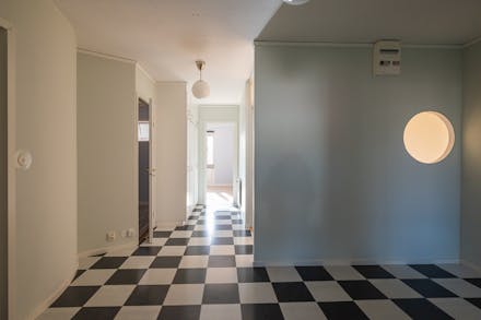 Schackmönstrat golv leder vidare till sovrum 2 och vi passerar hall med gott om förvaring