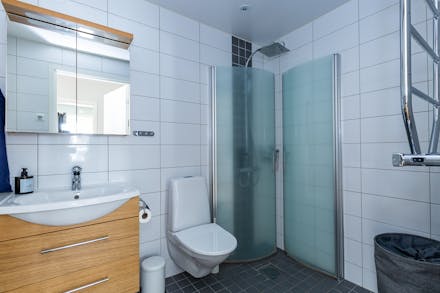 Badrum med kakel/klinker och dusch med vikväggar